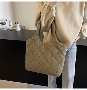 Detail of olive green quilted tote bag with large diamond stitching and wide shoulder strap