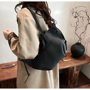 Detail view of geometric black PU leather tote bag with unique knot design on shoulder strap