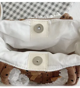 Dettaglio della chiusura magnetica in metallo su una borsa in cotone marrone a pois