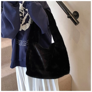 Sac fourre-tout noir en fausse fourrure porté avec une tenue d'automne décontractée