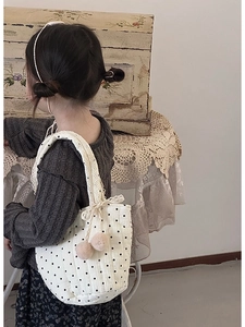 Détail du sac à bandoulière en coton matelassé avec dentelle et pompons roses