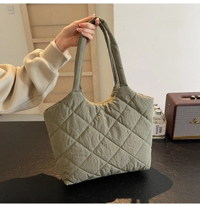 Detail of green quilted tote bag showing high-quality lightweight fabric texture and hand grip