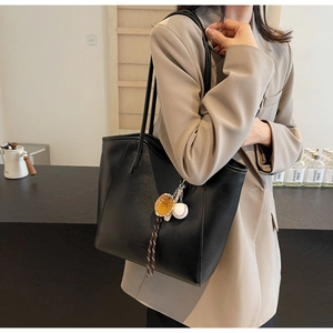 Sac fourre-tout noir minimaliste en similicuir avec charm de baseball sur modèle