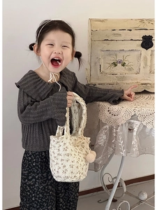 Détail d'un sac à main floral en coton avec dentelle et pompon pour petite fille