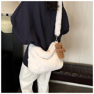 Détail du sac à bandoulière en peluche blanche avec un charmant petit ours brun attaché