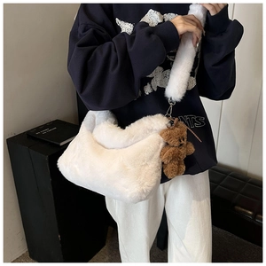 Détail du sac hobo en peluche blanche avec texture douce et breloque ours brun