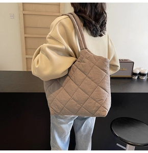 Detailed view of the quilted taupe tote bag showing natural drape and spacious shoulder fit