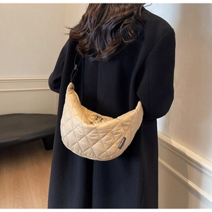 Detailed back view of a beige quilted hobo bag on a model showing size and shape