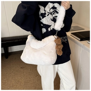 Détail d'un sac à bandoulière en peluche blanche avec fausse fourrure et breloque ours