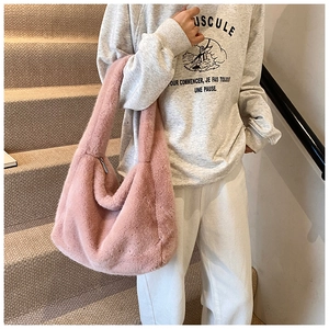 Gros plan d'un sac cabas en peluche rose avec texture douce et fermeture éclair en métal