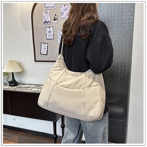 Detailed view of beige crossbody bag with large capacity pockets and nylon texture