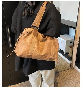 Détail d'un grand sac bandoulière en similicuir marron vintage avec une texture usée