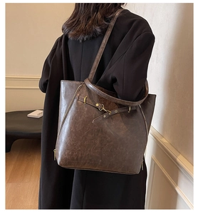 Detail view of deep brown vintage PU leather tote bag with side zippers and metal buckles