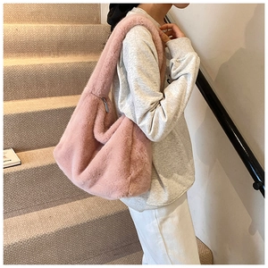 Détail du sac à épaule en fausse fourrure rose avec bandoulière large dans un décor épuré