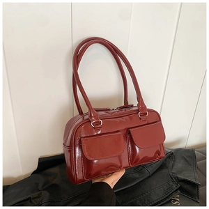 Chic burgundy glossy patent leather shoulder bag with dual front pockets and top handles