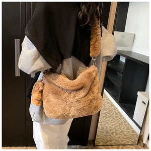 Détail d'un sac à bandoulière en peluche marron avec un joli pendentif ours assorti