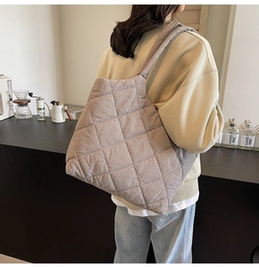 Detail of taupe quilted tote bag featuring classic diamond pattern for casual style