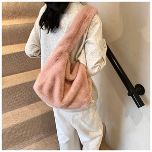 Détail du sac hobo rose en fausse fourrure avec large bandoulière en situation réelle