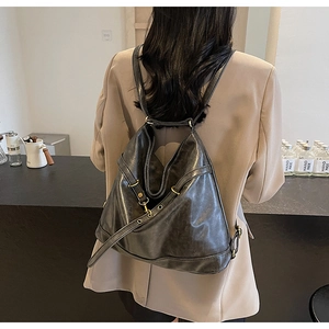Detail showing vintage textured PU leather backpack with metallic ring and functional straps