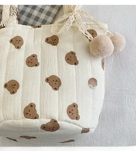 Détail du sac cabas en coton matelassé avec motifs d'ours et nœuds en dentelle