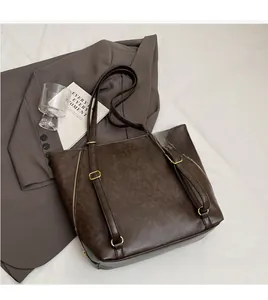 Detail of smooth long straps on dark brown large PU leather tote bag for women