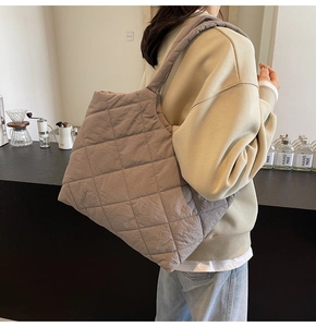 Detailed view of taupe quilted puffer tote bag with wide strap for casual commuting use