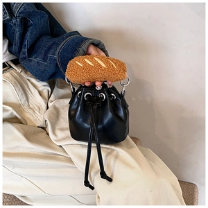 Detail of black PU leather bucket bag featuring a unique brown plush baguette handle