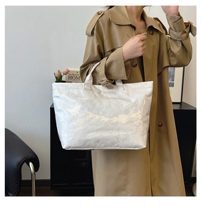 Detail of white Tyvek tote bag with wrinkled texture and printed TOTE BAG text