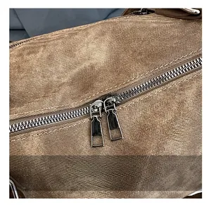 Détails de la double fermeture éclair métallique et texture vintage du sac cabas
