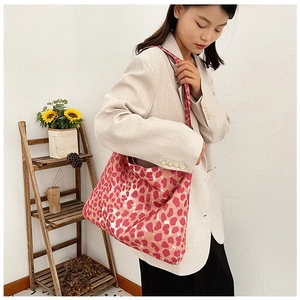 Detailed view of pink leopard print canvas tote bag styled with casual beige suit