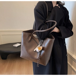 Détail du grand sac cabas en cuir PU marron foncé avec un pendentif de baseball