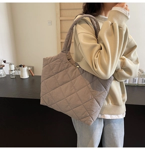 Detailed view of quilted tote bag in taupe nylon with soft padded texture and top handles