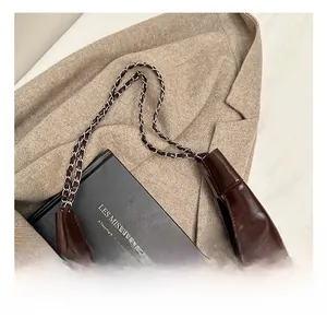 Dettaglio della borsa tote in pelle cerata marrone scuro con tracolla a catena