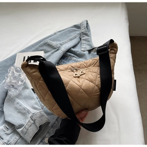 Quilted khaki half-moon crossbody bag with wide black strap on casual background