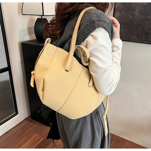 Detail view of the sleek light beige PU leather tote bag with unique diagonal stitching