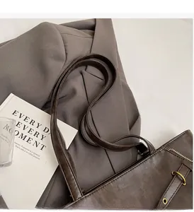 Detail of dark brown tote bag with matte leather finish and long double shoulder straps