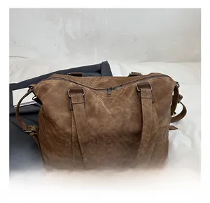 Détail d'un grand sac bandoulière en similicuir marron vintage avec crochets métalliques