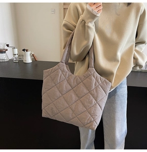 Close-up of the quilted diamond pattern on a spacious taupe tote bag for women