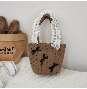 Dettaglio borsa in tela marrone a pois con fiocchi neri e manici in pizzo bianco
