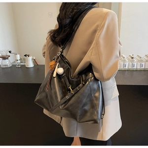 Large black PU leather tote bag with decorative charms shown from a 45-degree side view