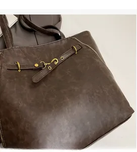 Detailed close-up of dark brown PU tote bag showing soft leather texture and golden zippers