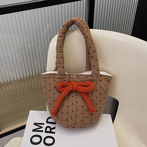 Brown polka dot quilted tote bag with a bright orange knit bow and bucket design