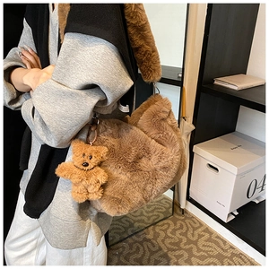 Détail du sac à épaule en peluche marron avec texture de fausse fourrure et breloque ours