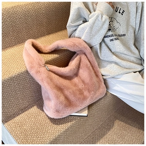 Détail du sac cabas en fausse fourrure rose avec fermeture éclair argentée sur tapis