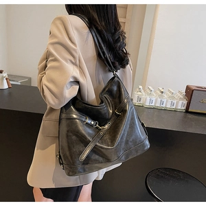Detailed side view of the black PU leather shoulder bag with vintage gold metal buckles
