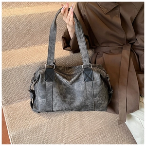 Détail d'un grand sac cabas avec texture marbrée, anses en cuir et ferrures métalliques