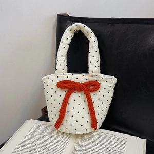 Quilted white cotton handbag with black polka dots and a large orange knit bow decor