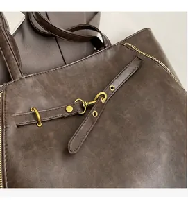 Detailed macro view of dark brown PU leather surface with vintage metal buckle and zipper