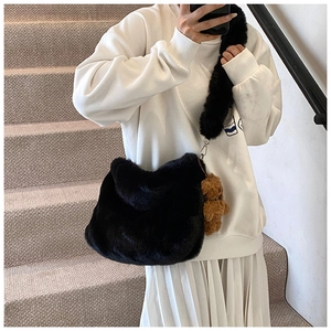 Détail du sac à épaule en fausse fourrure noire avec pendentif ours pour l'hiver