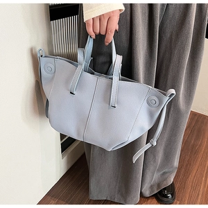 Detailed view of light blue PU leather tote bag with decorative stitching and round texture